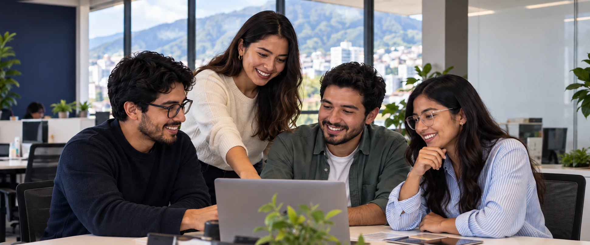 Un equipo colabora alrededor de una computadora en una oficina luminosa.